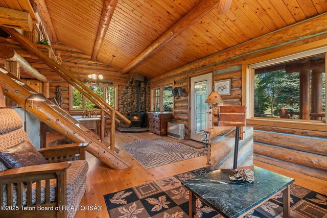 5100 Country Club Dr, Victor, ID 83455 - living room with stairs, log walls, a wood stove, hardwood / wood-style flooring, and wood ceiling
