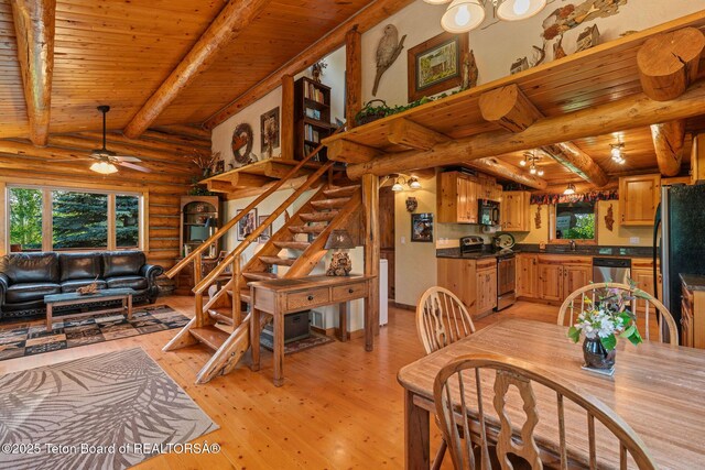 5100 Country Club Dr, Victor, ID 83455 - dining space featuring log walls, a wood ceiling with exposed beams, plenty of natural light, stairs, and light wood-type flooring
