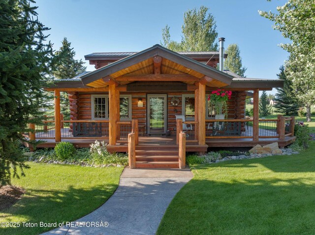 5100 Country Club Dr, Victor, ID 83455 - cabin with log exterior, a front yard, and a metal roof