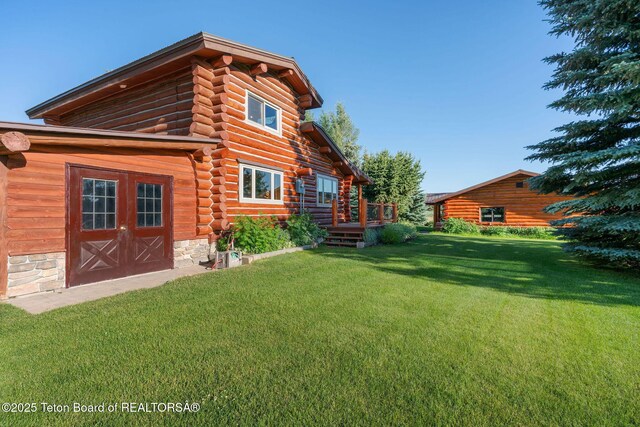 5100 Country Club Dr, Victor, ID 83455 - rear view of property with log exterior, a lawn, and a deck