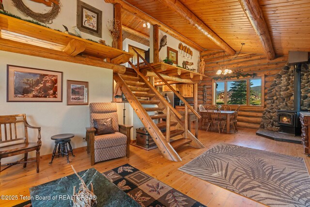 5100 Country Club Dr, Victor, ID 83455 - staircase featuring log walls, a wood stove, wood-type flooring, a wood ceiling with exposed beams, and a chandelier