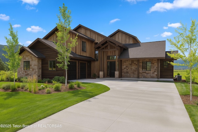 555 Silver Fox Ln, Victor, ID 83455 - view of front of house featuring stone siding, a garage, driveway, a front lawn, and board and batten siding