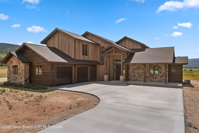 555 Silver Fox Ln, Victor, ID 83455 - view of front facade featuring stone siding, concrete driveway, an attached garage, and a shingled roof