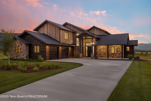 555 Silver Fox Ln, Victor, ID 83455 - view of front of property with stone siding, driveway, a front yard, and a garage