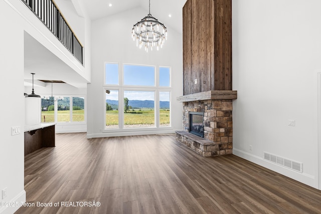 555 Silver Fox Ln, Victor, ID 83455 - unfurnished living room with a chandelier, a fireplace, dark wood-type flooring, high vaulted ceiling, and a mountain view