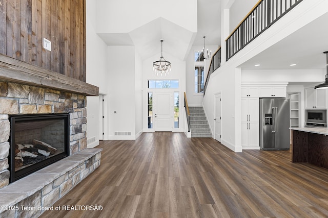 555 Silver Fox Ln, Victor, ID 83455 - foyer featuring a high ceiling, a stone fireplace, dark wood-type flooring, a chandelier, and stairway