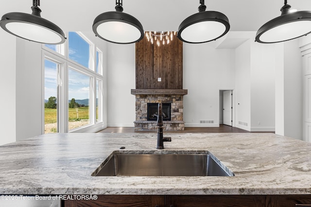 555 Silver Fox Ln, Victor, ID 83455 - kitchen with a high ceiling, healthy amount of natural light, light stone counters, a fireplace, and wood finished floors