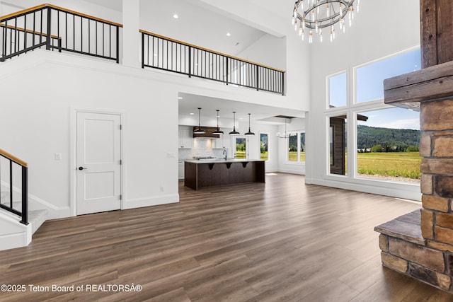 555 Silver Fox Ln, Victor, ID 83455 - unfurnished living room with a chandelier, a high ceiling, dark wood-type flooring, recessed lighting, and stairs