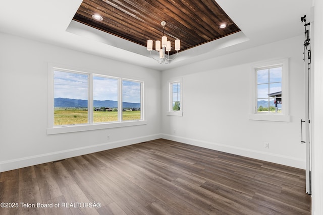 555 Silver Fox Ln, Victor, ID 83455 - spare room with a tray ceiling, a barn door, a chandelier, wooden ceiling, and healthy amount of natural light