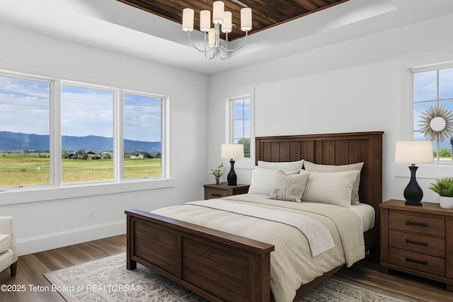 555 Silver Fox Ln, Victor, ID 83455 - bedroom with a raised ceiling, wood ceiling, a chandelier, a mountain view, and wood finished floors