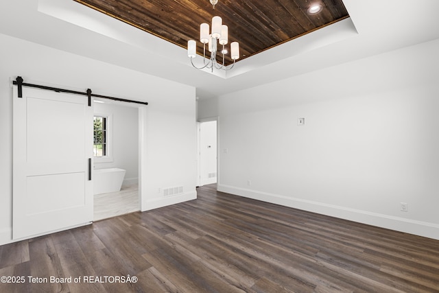 555 Silver Fox Ln, Victor, ID 83455 - unfurnished room with a tray ceiling, wood ceiling, a barn door, dark wood-type flooring, and a chandelier