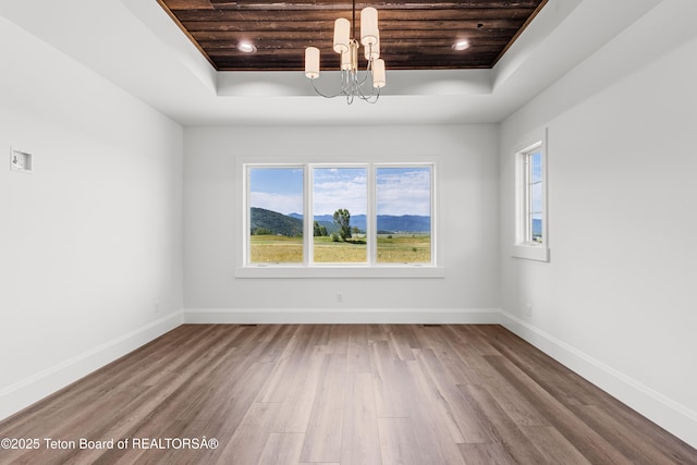 555 Silver Fox Ln, Victor, ID 83455 - empty room with a raised ceiling, wood ceiling, a chandelier, wood finished floors, and plenty of natural light