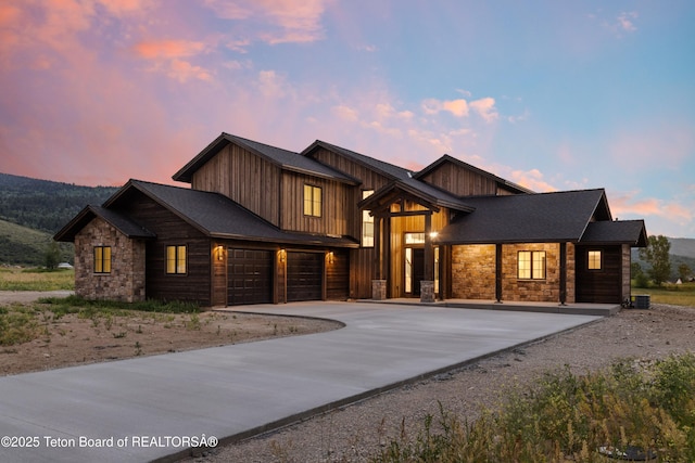 555 Silver Fox Ln, Victor, ID 83455 - view of front facade with stone siding, concrete driveway, a garage, and an attached garage