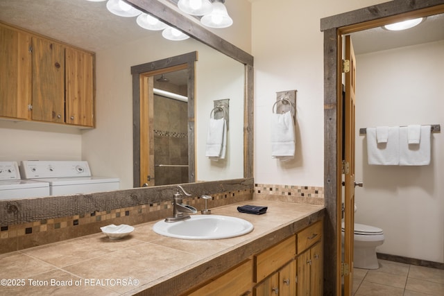 3885 S Lake Creek Dr Unit 1013, Wilson, WY 83014 - full bathroom featuring separate washer and dryer, vanity, a shower with shower door, and tile patterned floors