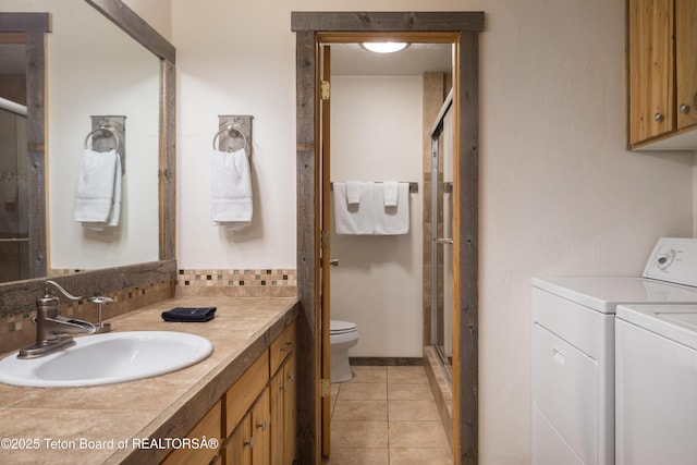 3885 S Lake Creek Dr Unit 1013, Wilson, WY 83014 - bathroom featuring independent washer and dryer, a shower stall, vanity, and tile patterned floors