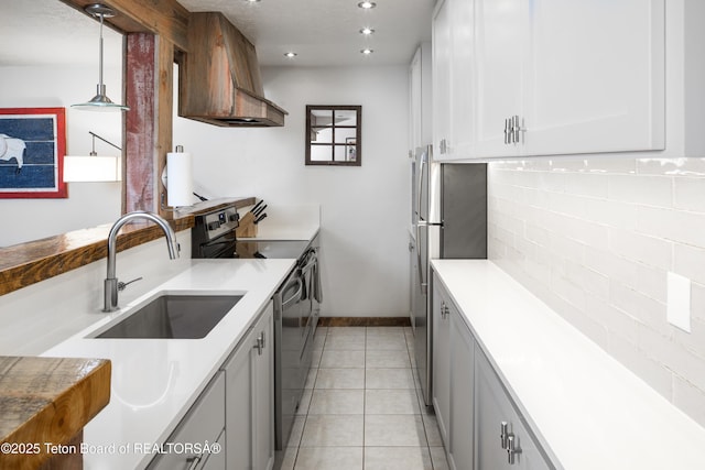 3885 S Lake Creek Dr Unit 1013, Wilson, WY 83014 - kitchen featuring appliances with stainless steel finishes, custom exhaust hood, backsplash, decorative light fixtures, and light countertops