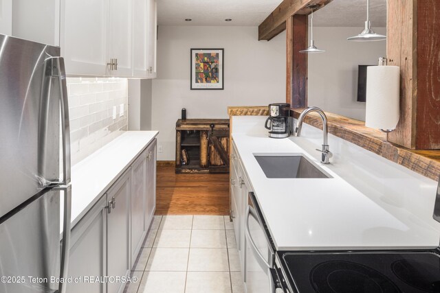 3885 S Lake Creek Dr Unit 1013, Wilson, WY 83014 - kitchen with freestanding refrigerator, dishwasher, light countertops, tasteful backsplash, and pendant lighting
