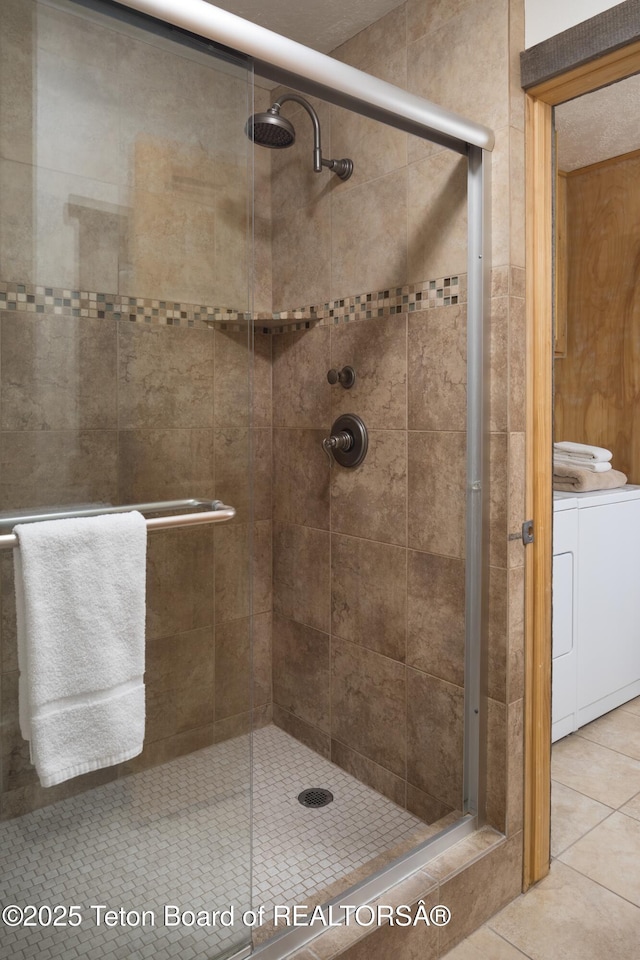 3885 S Lake Creek Dr Unit 1013, Wilson, WY 83014 - full bathroom featuring independent washer and dryer, a stall shower, and tile patterned flooring