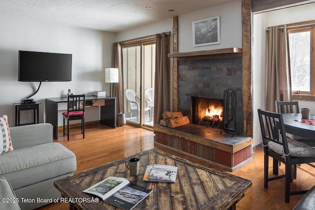 3885 S Lake Creek Dr Unit 1013, Wilson, WY 83014 - living room with a lit fireplace, light wood-style flooring, and a textured ceiling
