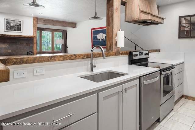 3885 S Lake Creek Dr Unit 1013, Wilson, WY 83014 - kitchen featuring stainless steel appliances, custom exhaust hood, light tile patterned flooring, decorative light fixtures, and a textured ceiling
