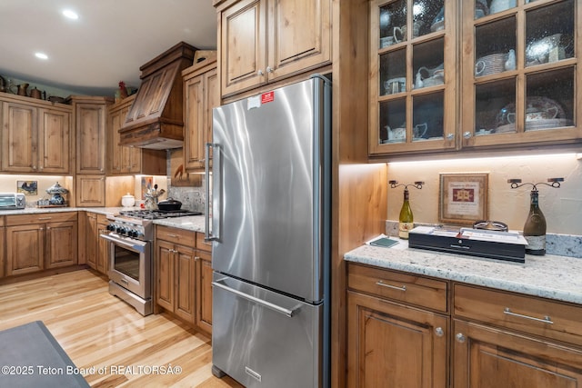 6289 Fox Meadows Dr, Victor, ID 83455 - kitchen with stainless steel appliances, light wood-type flooring, brown cabinets, light stone counters, and recessed lighting