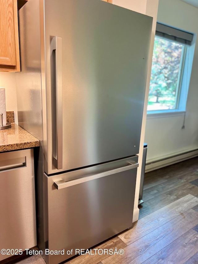 220 Homestead Rd Unit 203, Victor, ID 83455 - kitchen view of freestanding refrigerator, a baseboard heating unit, wood finished floors, and light stone countertops