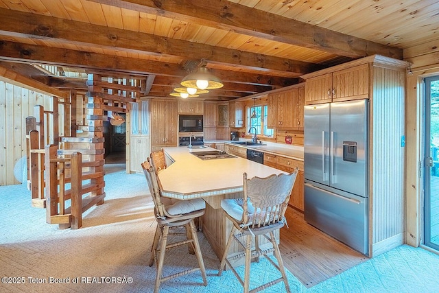 386 Dogwood Dr, Star Valley Ranch, WY 83127 - kitchen featuring black appliances, light countertops, a wood ceiling with exposed beams, light colored carpet, and wooden walls