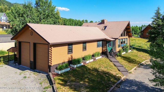 386 Dogwood Dr, Star Valley Ranch, WY 83127 - log cabin with log siding, a chimney, a front yard, a metal roof, and a detached garage