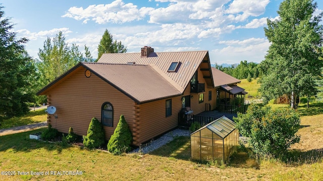 386 Dogwood Dr, Star Valley Ranch, WY 83127 - back of house with log siding, an exterior structure, an outbuilding, a chimney, and a yard