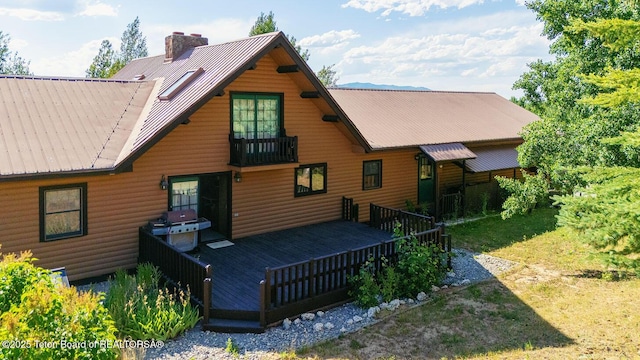 386 Dogwood Dr, Star Valley Ranch, WY 83127 - back of property with log veneer siding, a chimney, a metal roof, and a wooden deck