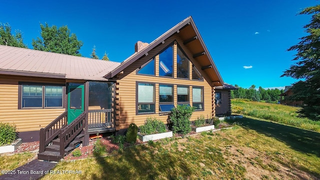 386 Dogwood Dr, Star Valley Ranch, WY 83127 - log cabin with log siding, a chimney, a front lawn, and a metal roof