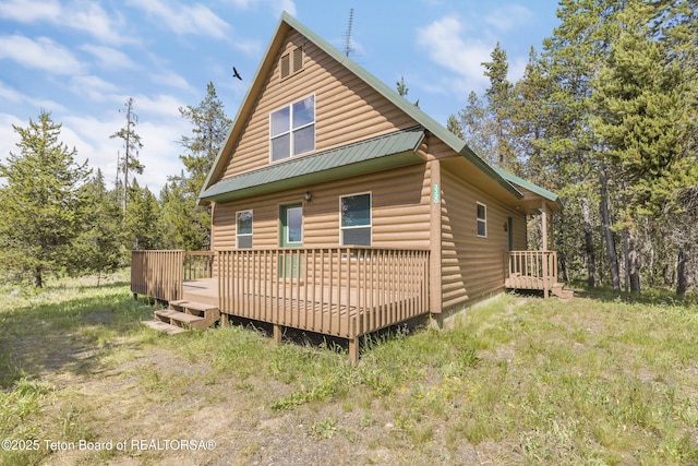 3320 Griffel Ct, Island Park, ID 83429 - back of property with a wooden deck, faux log siding, and a metal roof