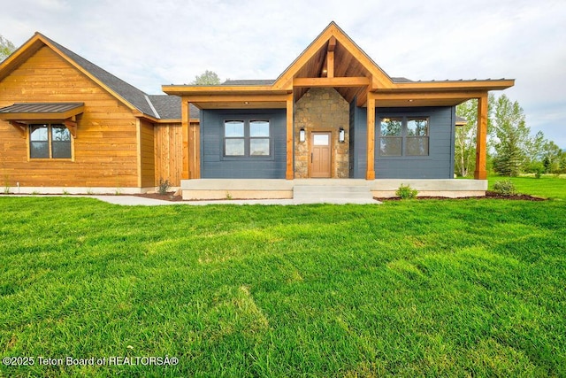 245 Pond Dr, Victor, ID 83455 - view of front of home featuring a front yard, stone siding, and a porch