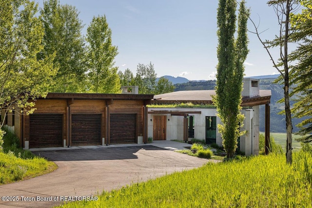 1955 W Bohnetts Rd, Jackson, WY 83001 - contemporary home featuring asphalt driveway, a mountain view, and a garage
