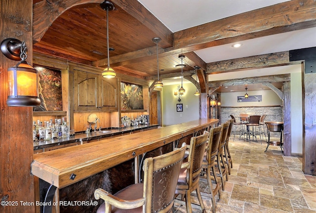 70 Hastings Dr, Victor, ID 83455 - indoor wet bar featuring stone tile flooring, beamed ceiling, pendant lighting, and arched walkways