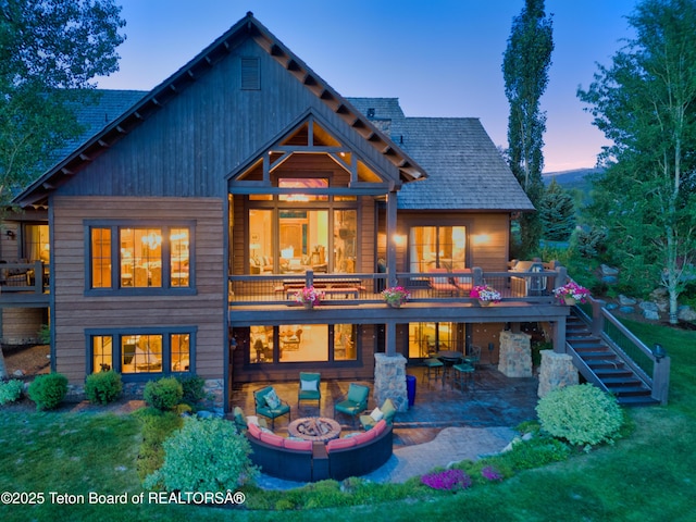 70 Hastings Dr, Victor, ID 83455 - back of property at dusk featuring an outdoor fire pit, a patio, stairway, and a yard