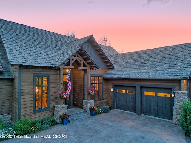 70 Hastings Dr, Victor, ID 83455 - view of front of property with driveway, an attached garage, and stone siding