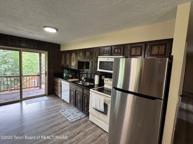 13280 N 3750 W, Felt, ID 83424 - kitchen with white appliances, a textured ceiling, light wood-style floors, dark brown cabinetry, and dark countertops
