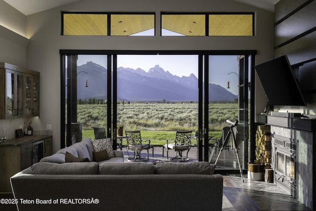 580 Moulton Loop Rd, Jackson, WY 83001 - living room featuring lofted ceiling, a glass covered fireplace, a bar, wine cooler, and wood finished floors