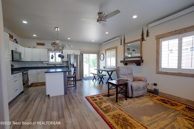 643 Country Club Way, Thayne, WY 83127 - kitchen featuring appliances with stainless steel finishes, a breakfast bar, dark countertops, white cabinetry, and recessed lighting