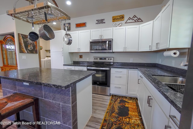 643 Country Club Way, Thayne, WY 83127 - kitchen with stainless steel appliances, washing machine and dryer, light wood-type flooring, white cabinets, and recessed lighting