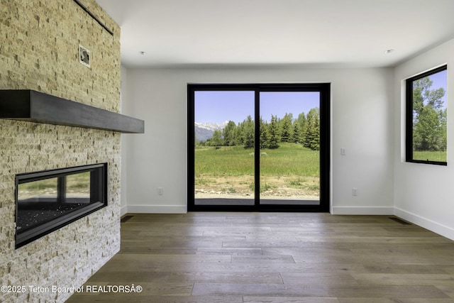 175 Huckleberry Dr, Jackson, WY 83001 - unfurnished living room with wood finished floors and a stone fireplace
