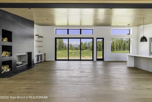 175 Huckleberry Dr, Jackson, WY 83001 - unfurnished living room with hardwood / wood-style flooring, a large fireplace, healthy amount of natural light, wooden ceiling, and a high ceiling