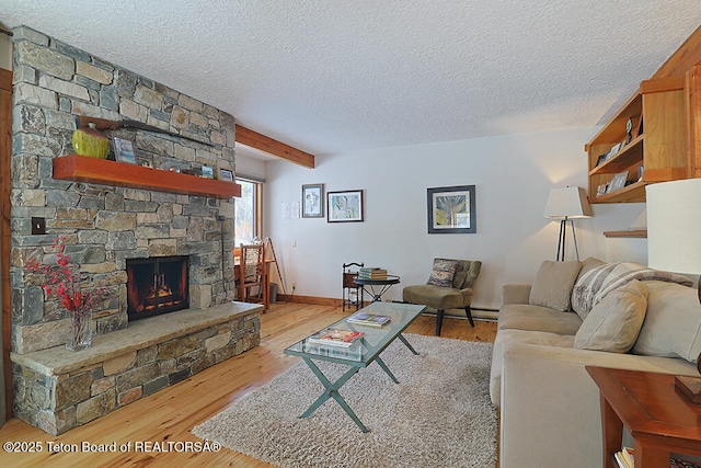 4435 Berry Dr Unit 3611, Wilson, WY 83014 - living room with a textured ceiling, wood finished floors, a stone fireplace, and beamed ceiling