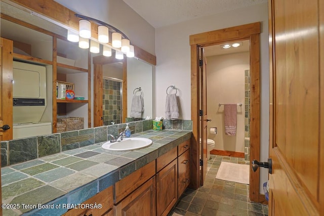 4435 Berry Dr Unit 3611, Wilson, WY 83014 - full bath featuring stacked washing machine and dryer, vanity, and stone finish flooring