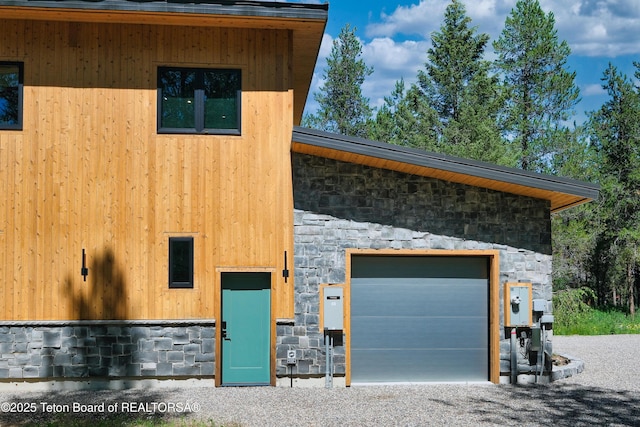 4327 Bridger Rdg, Ashton, ID 83420 - view of front facade featuring stone siding, an outbuilding, and a garage