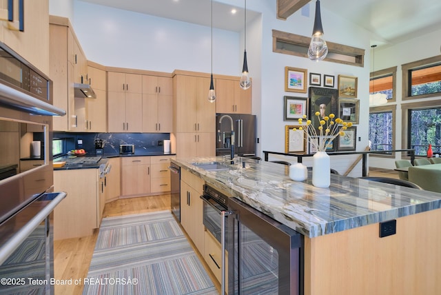 4327 Bridger Rdg, Ashton, ID 83420 - kitchen with light brown cabinetry, wine cooler, dark stone counters, decorative backsplash, and a spacious island