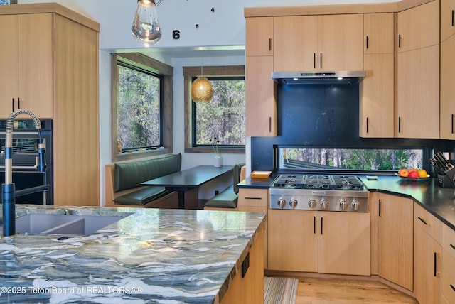 4327 Bridger Rdg, Ashton, ID 83420 - kitchen with stainless steel gas cooktop, extractor fan, light brown cabinetry, light wood finished floors, and decorative light fixtures