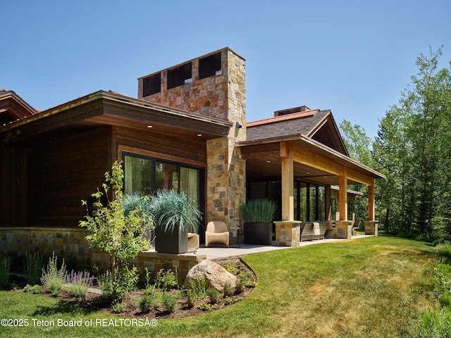 3220 N Teton Pines Dr, Wilson, WY 83014 - rear view of property with a yard, stone siding, and a patio area