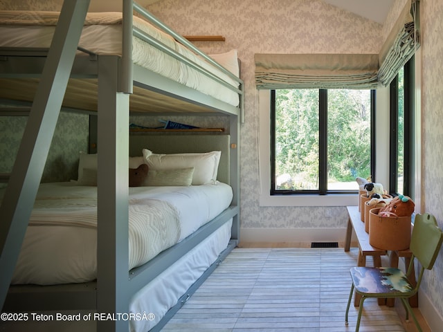 3220 N Teton Pines Dr, Wilson, WY 83014 - bedroom featuring wallpapered walls, lofted ceiling, and wood finished floors